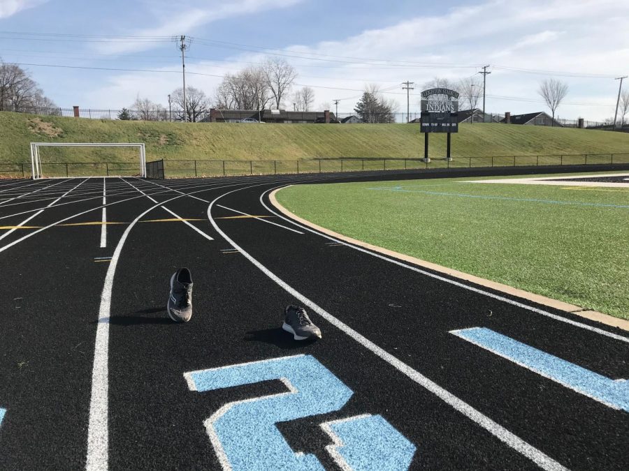 The track at Father Bly Field with a pair of sneakers in the middle of running.