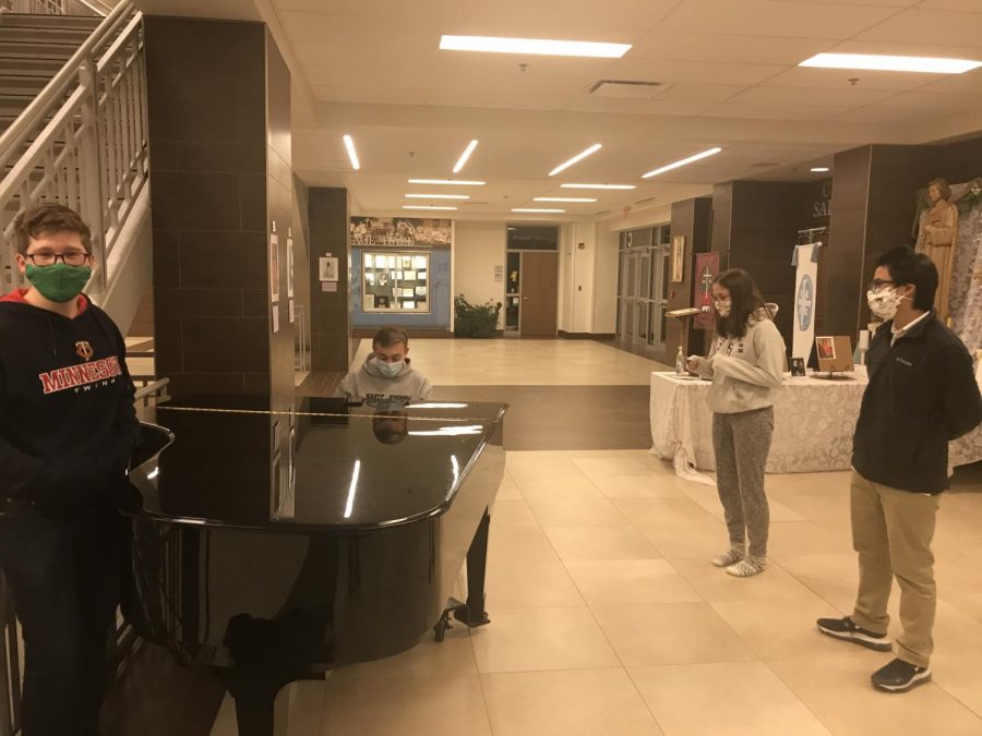 The team takes a break around the Piano